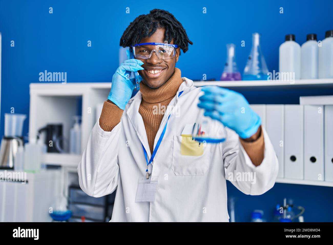 African american man scientist talking on the smartphone holding test ...