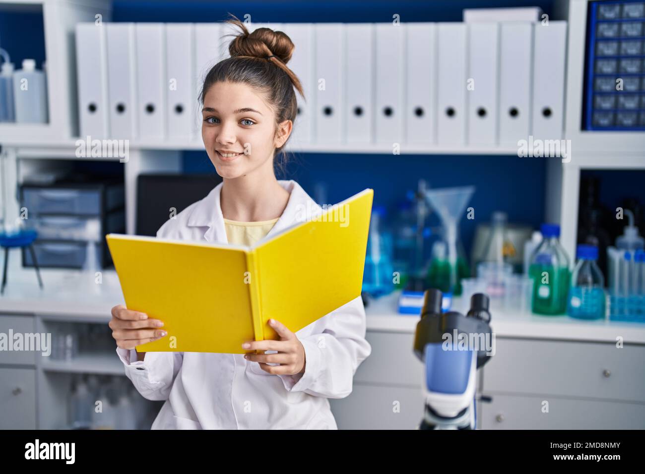 Adorable girl scientist reading book studying at laboratory Stock Photo ...