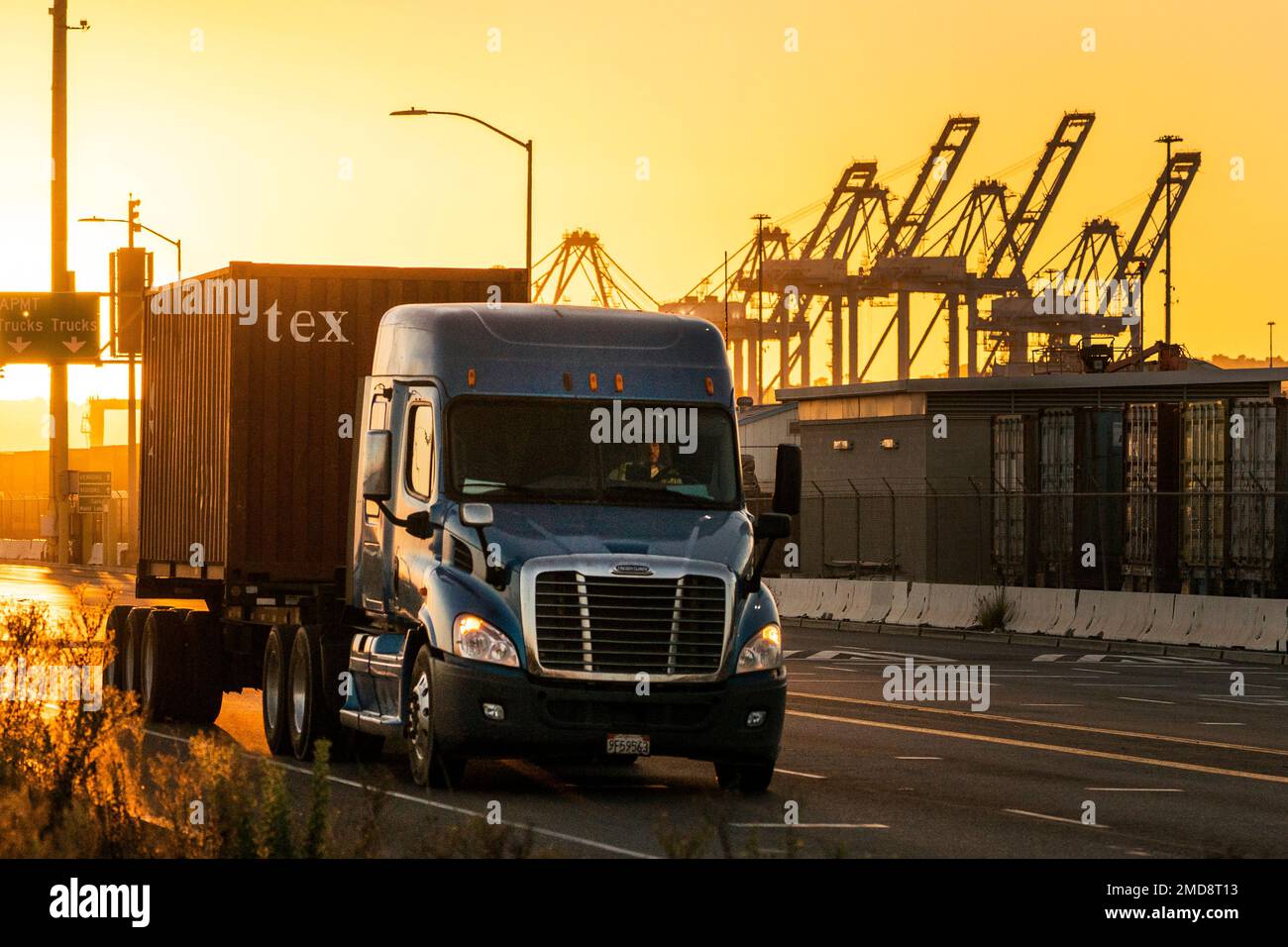 In this Monday, Oct. 18, 2021, photo a trucker transports a container