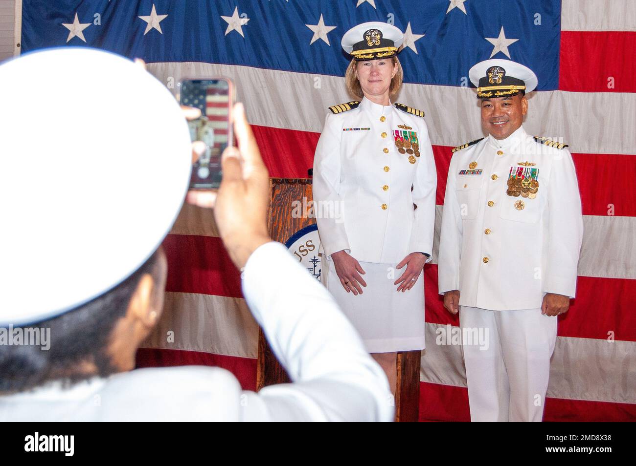 220714-N-YS140-001  A Navy Reserve Center (NRC) Alameda Sailor captures a picture of incoming commanding officer Capt. Kerri Chase aside outgoing commanding officer Capt. Roberto Dumlao at an NRC Alameda change of command ceremony aboard the USS Hornet (CV 12), Alameda, Calif., July 14, 2022. NRC Alameda was established after World War II and increased activity in the wake of the attacks on 9/11. The mission of the NRC is to provide customer service and enhance the mobilization readiness training for over 650 Navy Reservists. NRC Alameda is manned by 2 officers, 23 enlisted personnel and one D Stock Photo