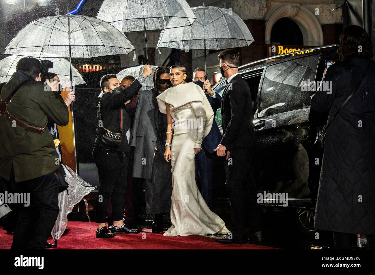 Zendaya is protected from the rain by umbrellas upon arrival at the