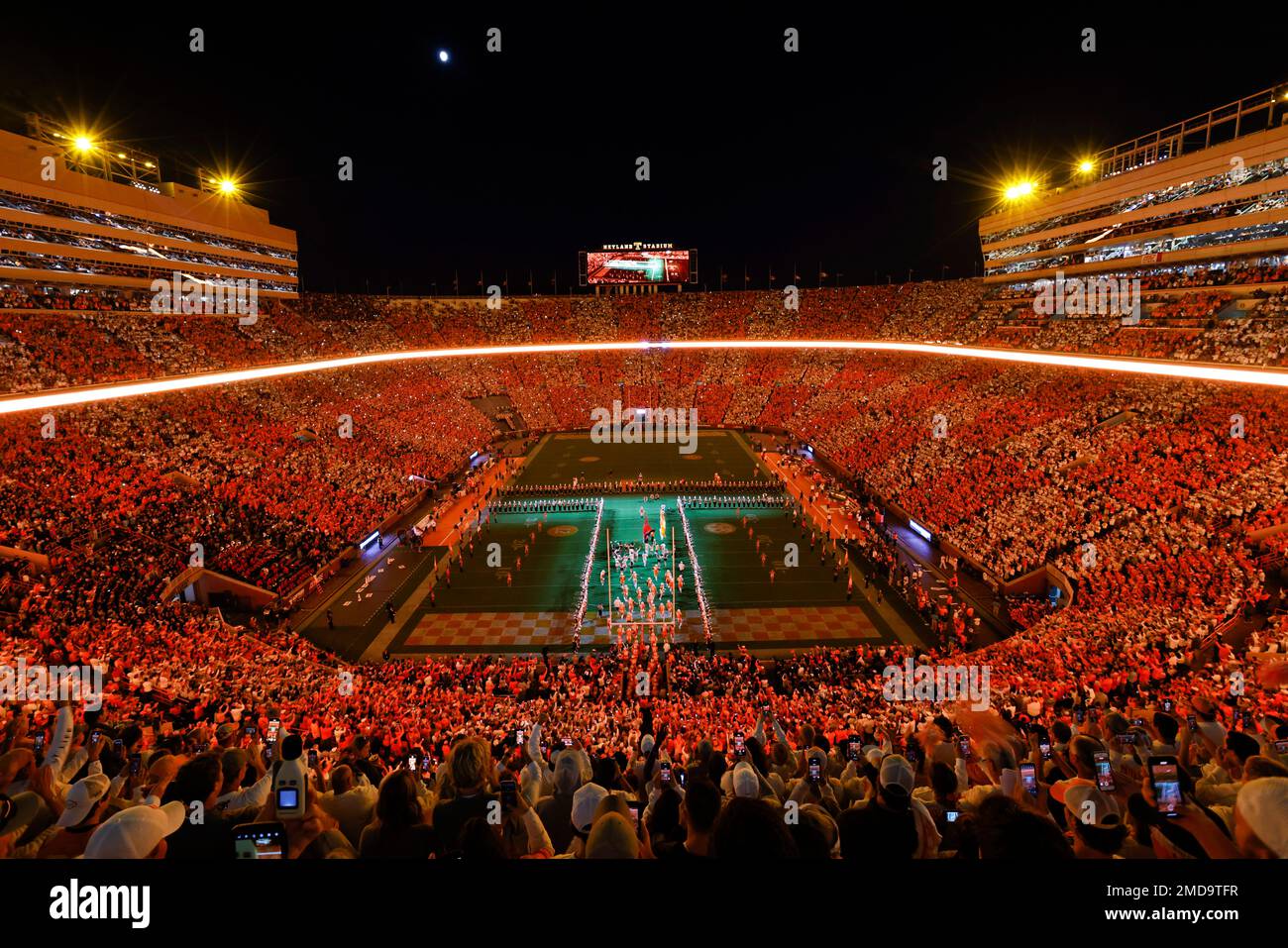Fans dressed in orange and white form the checkerboard pattern in Neyland  Stadium as Tennessee players run through the \, image size:1300x957