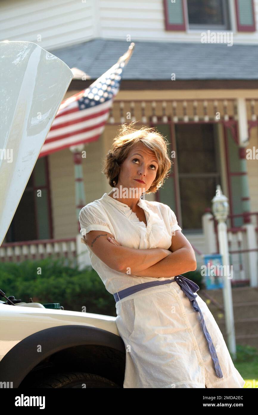 Pretty woman in a dress stranded with car trouble Stock Photo