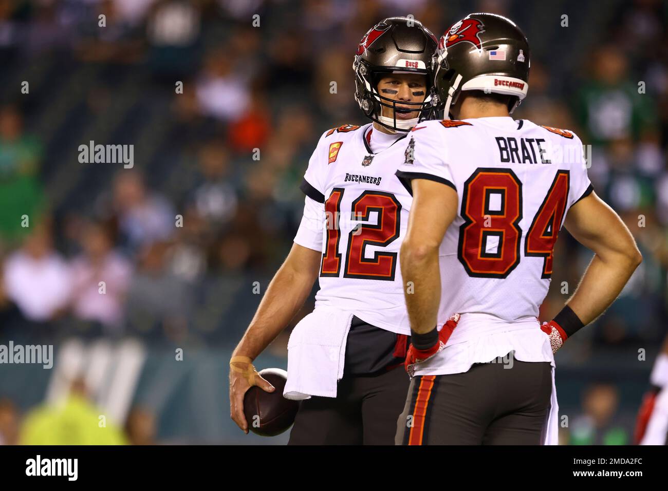 Tampa Bay Buccaneers quarterback Tom Brady (12) talks with tight end  Cameron Brate (84) before an NFL football game against the Philadelphia  Eagles, Thursday, Oct. 14, 2021, in Philadelphia. (AP Photo/Rich Schultz