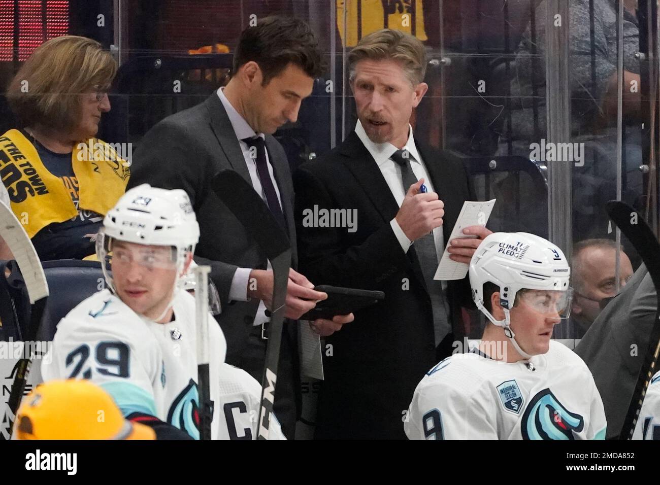 Seattle Kraken head coach Dave Hakstol, center right, talks with