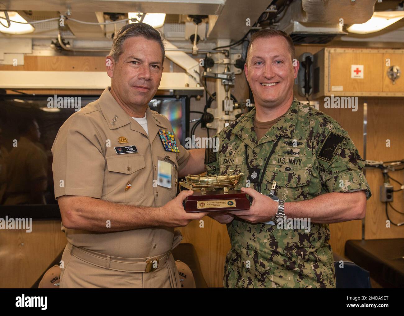 KINGS BAY, Ga. (July 14, 2022) Vice Adm. Juan Ricardo Rozo, Commander, Caribbean Naval Force, presents a gift to Cmdr. John Smith, commanding officer of the Ohio-class ballistic-missile submarine USS Alaska (SSBN 732) Blue Crew (right), during a visit aboard the ship. The visit to Naval Submarine Base Kings Bay, Georgia was part of the Diesel Electric Submarine Initiative (DESI) between the United States and partner nations. DESI is a program designed to train crews and test capabilities in Anti-Submarine Warfare between nuclear-powered and diesel-electric submarines. Stock Photo
