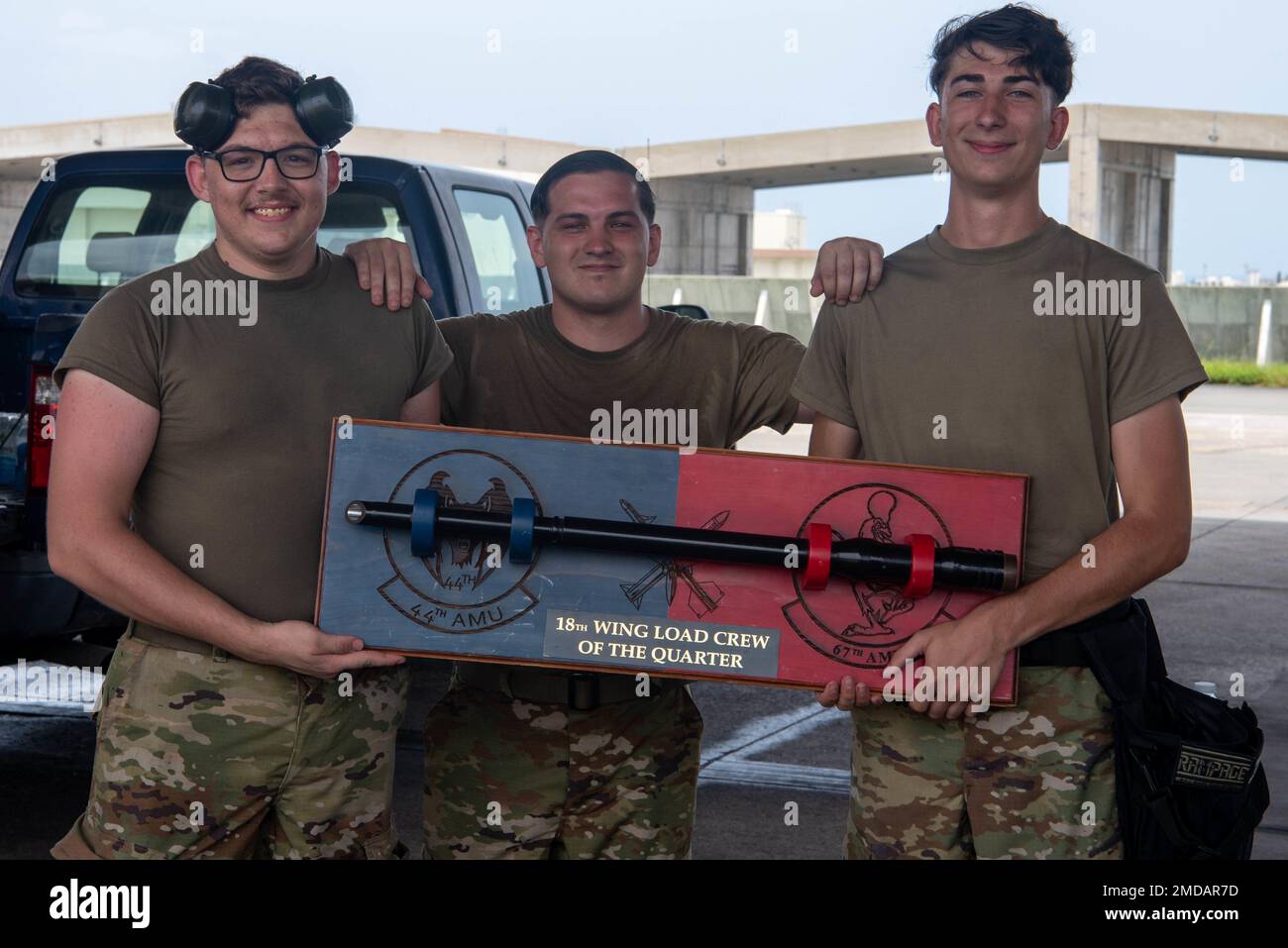 Airman 1st Class David Somers, 44th Aircraft Maintenance weapons load crew team member, left, Staff Sgt. Gabriel Gomez, 44th AMU weapons load crew team chief, center, and Airman 1st Class Jacob Herald, 44th AMU weapons load crew team member, right, pose with the trophy after winning the F-15 Load Crew of the Quarter Competition at Kadena Air Base, Japan, July 15, 2022. The friendly competition emphasizes fostering teamwork, knowledge proficiency, technical ability and performance. Stock Photo
