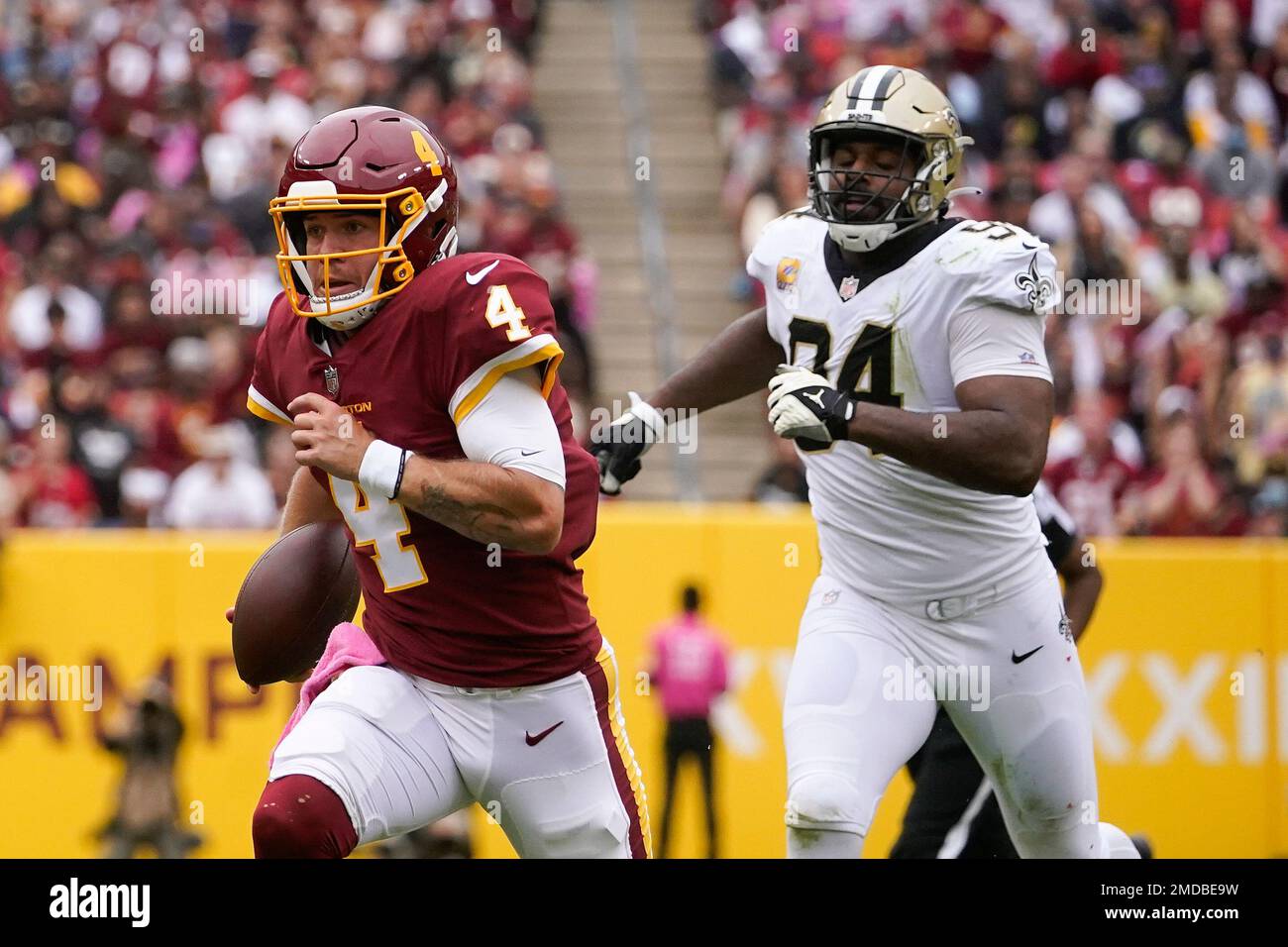 Washington Football Team quarterback Taylor Heinicke, left, rushes