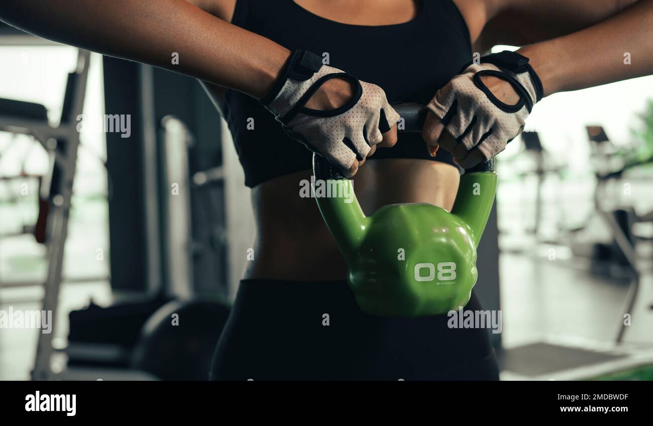 Close up of young woman doing exerce with kettlebell in gym. Stock Photo