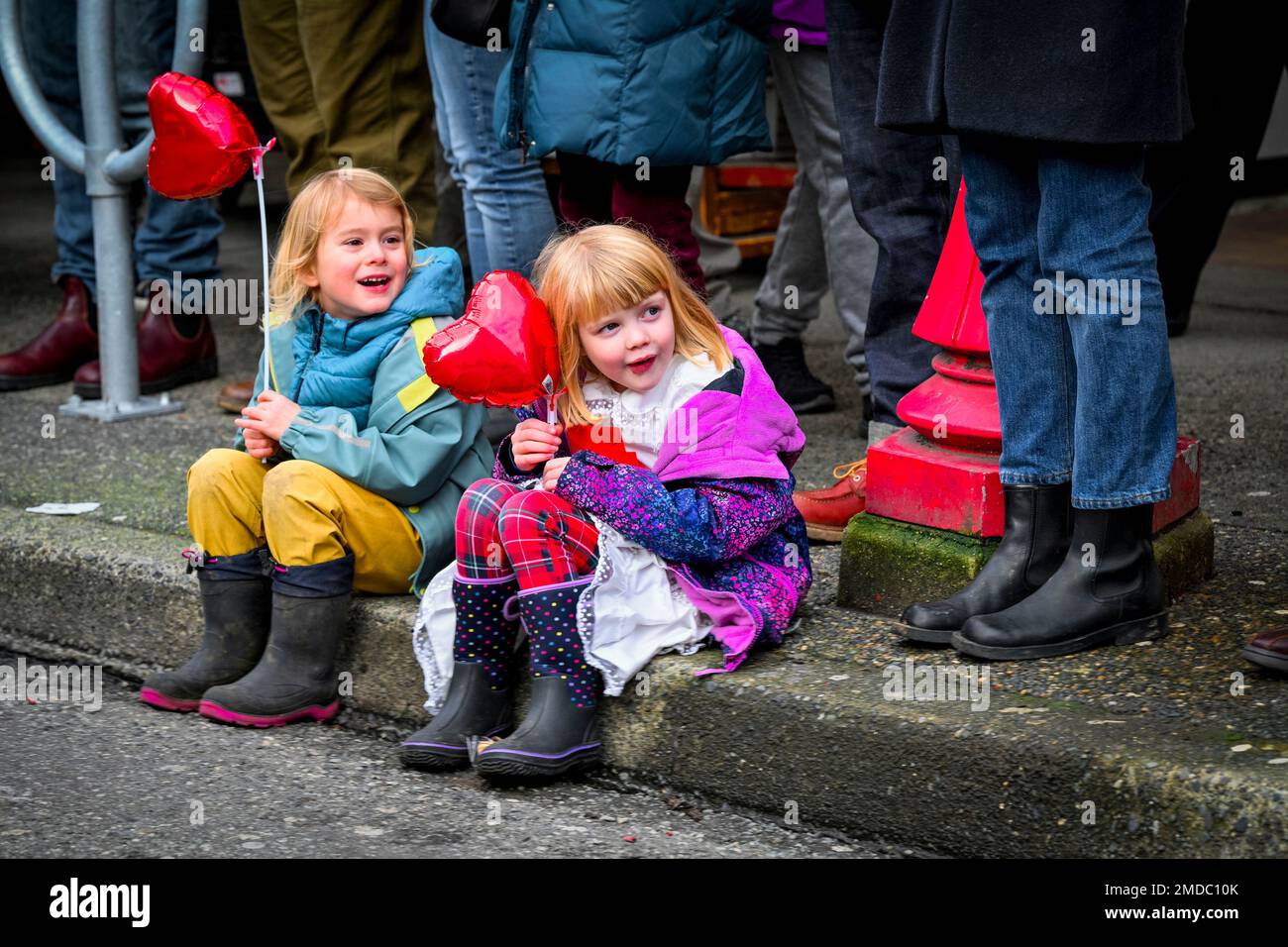 Young girls enjoy watching Chinese Lunar New Year Parade, Chinatown, Vancouver, British Columbia, Canada Stock Photo