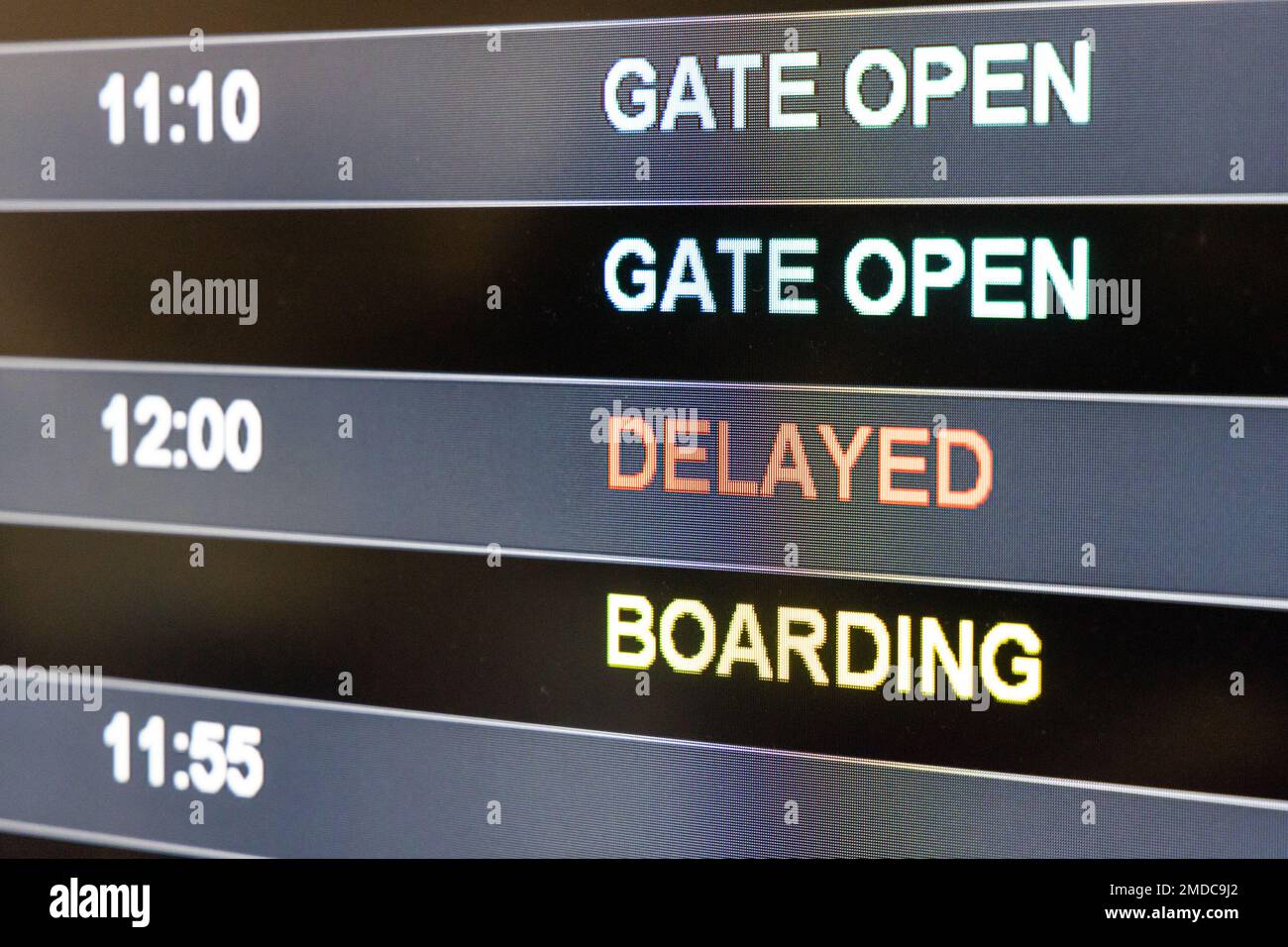 Close-up on airport flight information digital board with focus on word Delayed, Gate Open, Boarding Stock Photo
