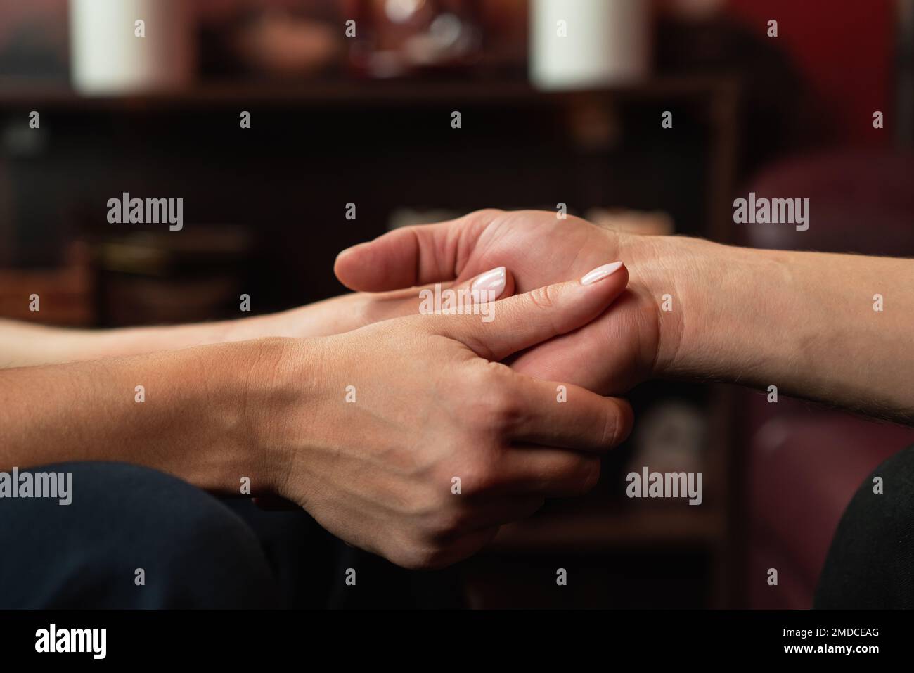 The therapist holds the hands of his patient during therapy. The concept of psychological assistance Stock Photo