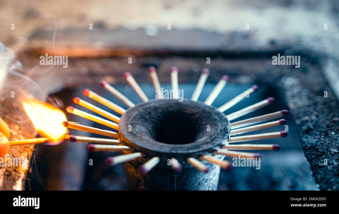 Ignition with a match of matches sticking out of the burner of a gas