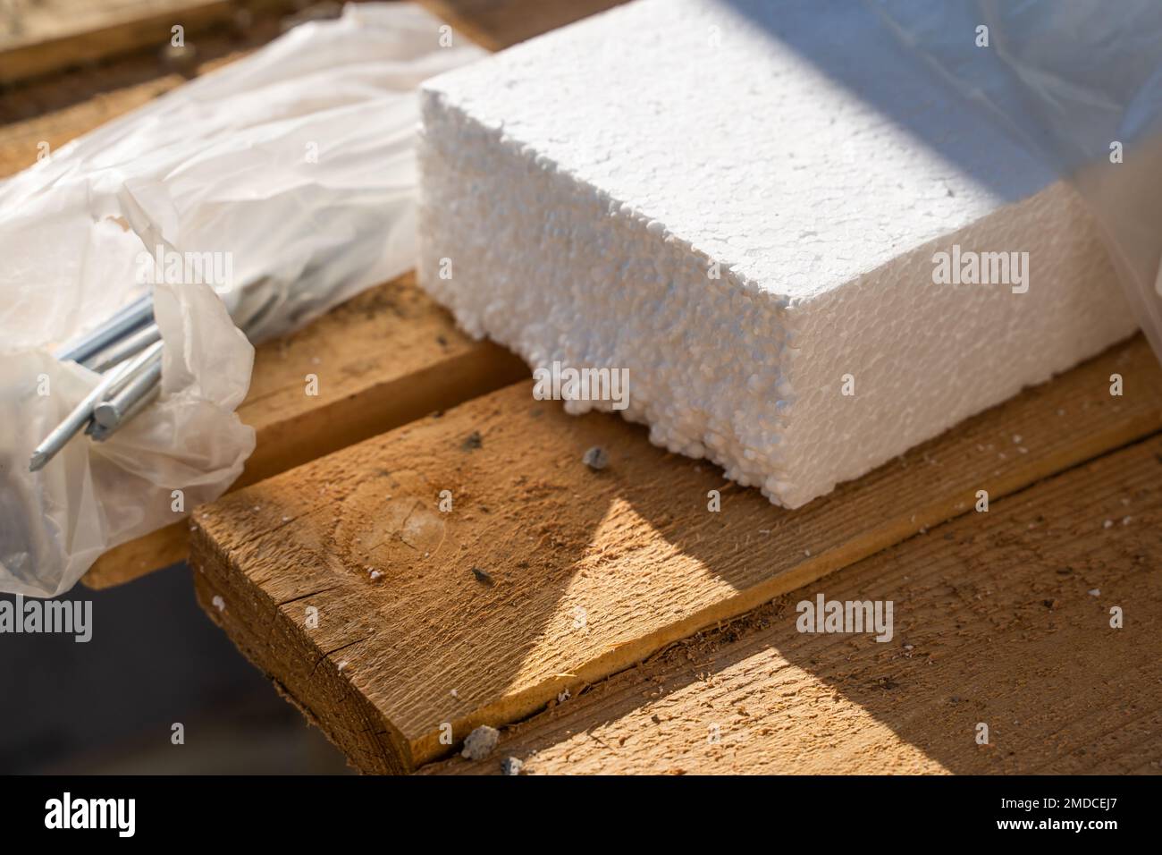 Thick white polystyrene foam for home insulation on wooden boards. Long