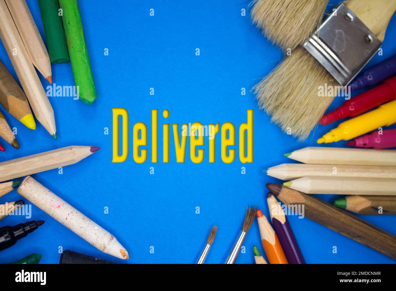 Overhead shot of school supplies with Delivered text. Brushes, pencils