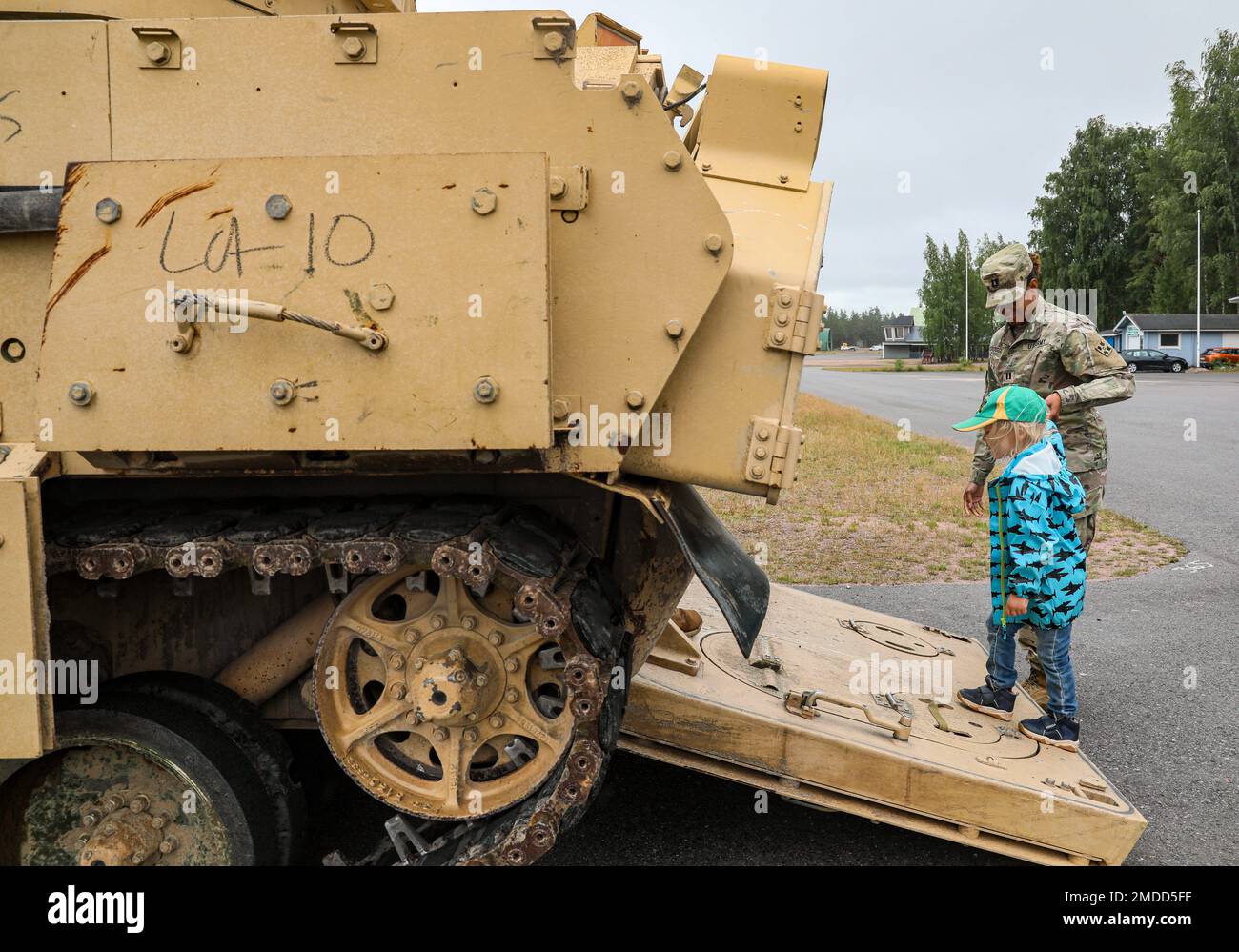 U.S. Army Capt. Paris Scroggins, assigned to the 3rd Armored Brigade Combat Team, 4th Infantry Division, escorts a child onto a U.S. Army M2 Bradley Fighting Vehicle during the Oripää Airshow at Säkylä, Finland, July 16, 2022. The 3rd Armored Brigade Combat Team, 4th Infantry Division, and the Pori Brigade of the Finnish army began summer training in Finland to strengthen relations and help build interoperability between the two nations. Stock Photo