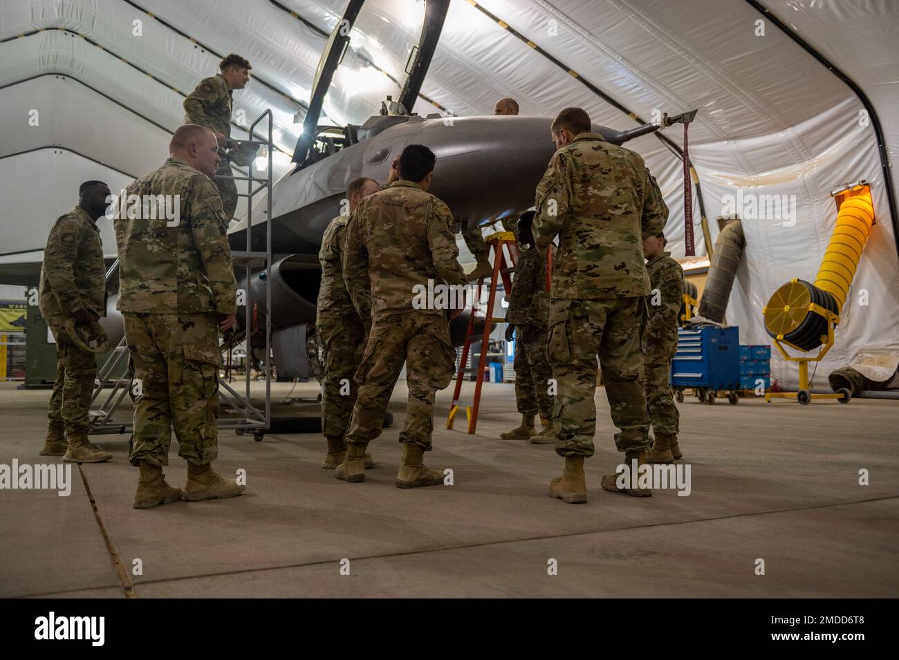 U.S. Air Force Airmen assigned to the 378th Air Expeditionary Wing tour an F-16 Fighting Falcon aircraft inside a hangar, at Prince Sultan Air Base, Kingdom of Saudi Arabia, July 15, 2022. The 378th Expeditionary Maintenance Squadron hosted an information session about the F-16 in an effort to strengthen relationships between various 378th AEW squadrons. Stock Photo