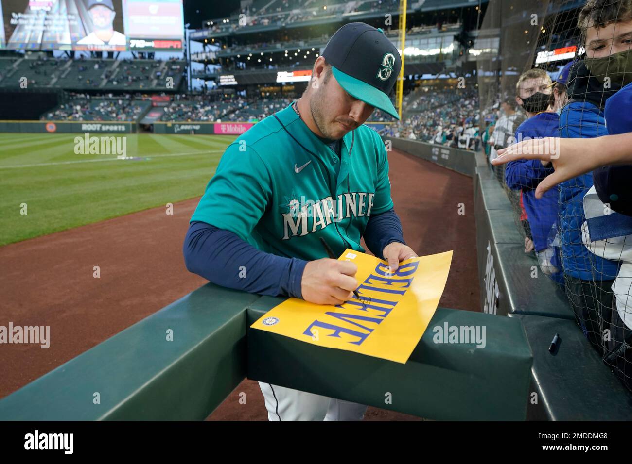 Seattle Mariners third baseman Ty France autographs a sign that reads  Believe before a baseball game against the Los Angeles Angels, Friday,  Oct. 1, 2021, in Seattle. Fans and the team have