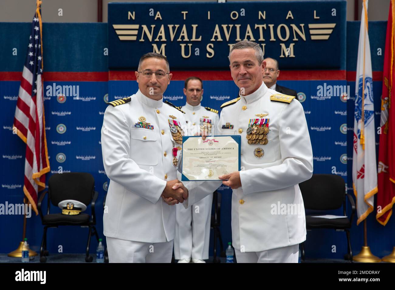 Rear Adm. Pete Garvin, commander, Naval Education and Training Command, right, presents the Legion of Merit to Capt. Marc W. Ratkus, commanding officer, Center for Information Warfare Training (CIWT), left, during the CIWT change of command ceremony at the National Naval Aviation Museum, July 22, 2022.  Capt. Christopher G. Bryant relieved Ratkus as CIWT’s commanding officer, while Ratkus also retired, concluding a 39-year military career. CIWT is charged with developing the future technical cadre of the Navy’s information warfare community. Stock Photo