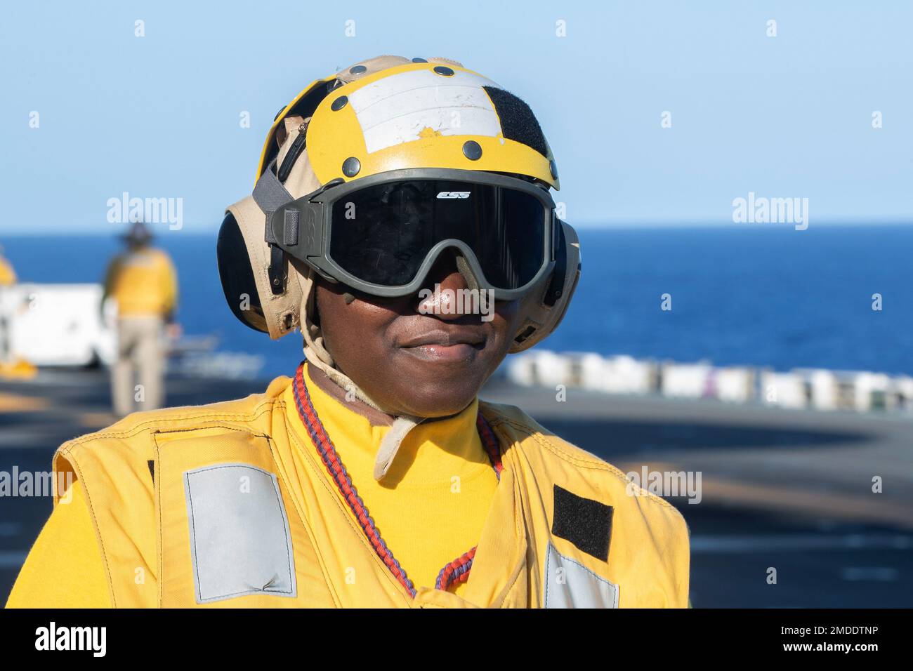 220722-N-XN177-2018 PACIFIC OCEAN (July 22, 2022) – Aviation Boatswain’s Mate (Handling) 1st Class Cortriee Gibbs, from Goldsboro, North Carolina, observes flight operations aboard amphibious assault carrier USS Tripoli (LHA 7), July 22, 2022. Tripoli is operating in the U.S. 7th Fleet area of operations to enhance interoperability with allies and partners and serve as a ready response force to defend peace and maintain stability in the Indo-Pacific region. Stock Photo