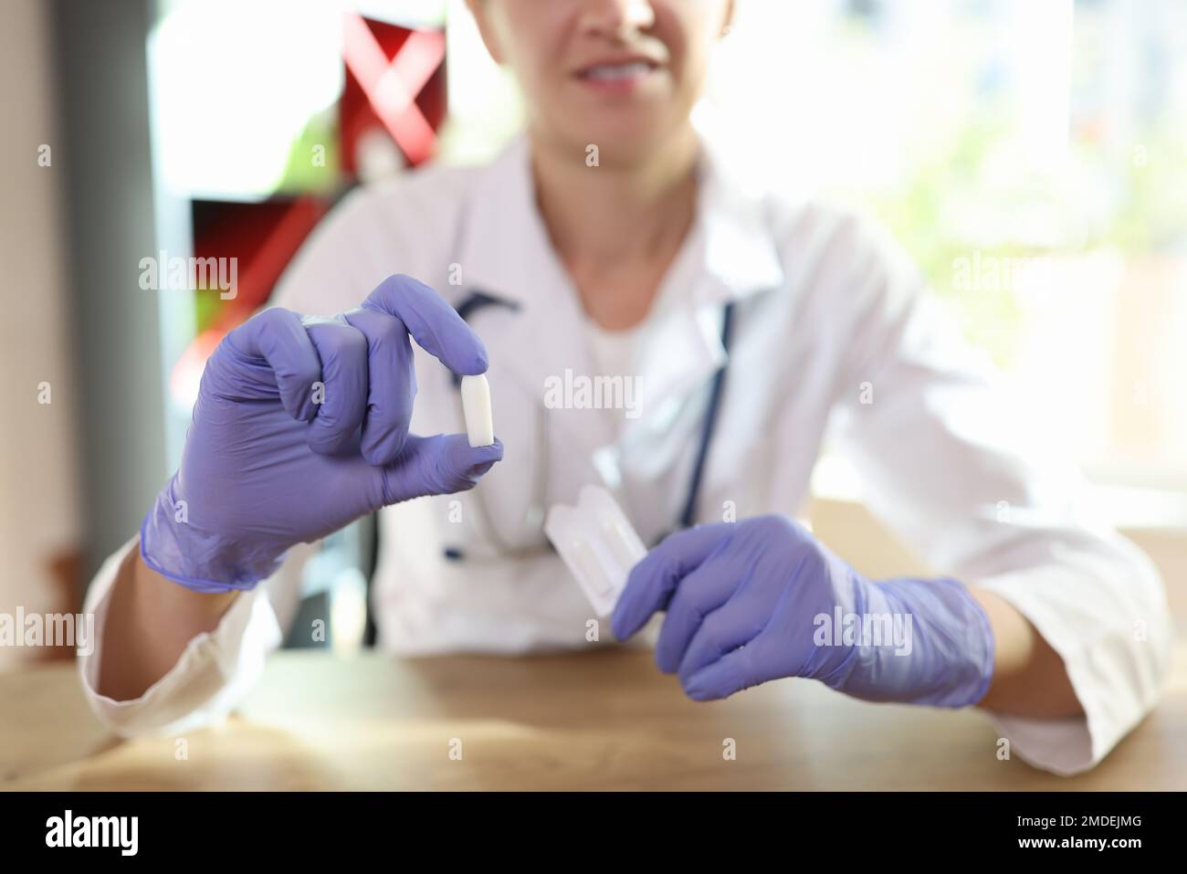 Doctor in latex gloves shows suppositories for anal or vaginal use. Stock Photo