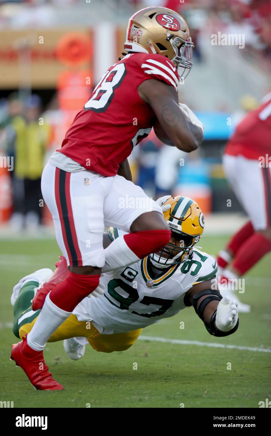 Green Bay Packers' Kenny Clark (97) attempts to bring down San Francisco  49ers Trey Sermon (28) during an NFL football game, Sunday, Sept. 26, 2021,  in Santa Clara, Calif. (AP Photo/Scot Tucker