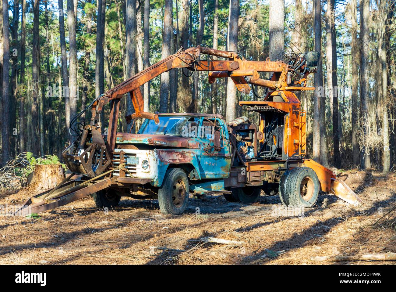 Abandoned non-working broken construction equipment in the forest near Caddo lake in Texas Stock Photo