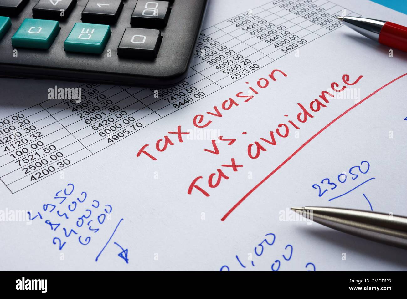 Handwritten inscription tax evasion vs tax avoidance on a piece of paper. Stock Photo