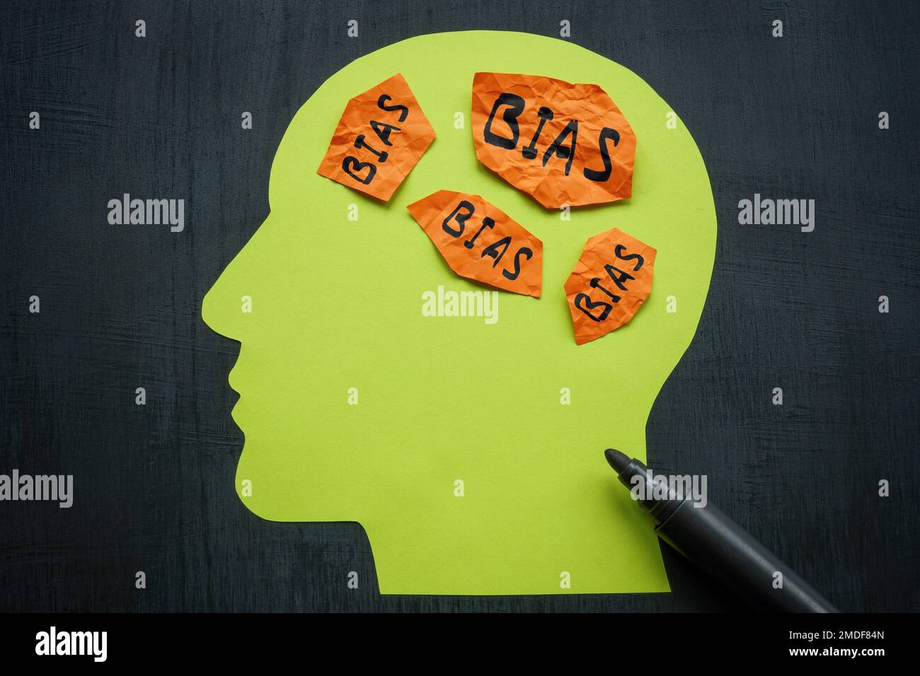 Paper in the shape of a head and sheets with the inscription bias. Stock Photo