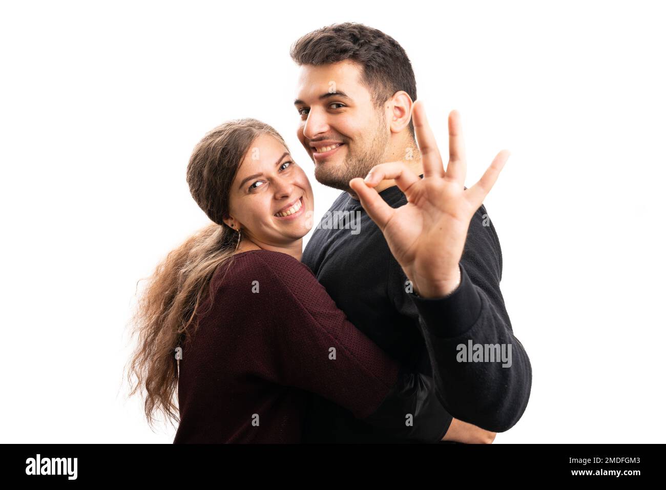 Cheerful girlfriend hugging adult boyfriend making okay gesture with fingers as romance love couple concept isolated on white background Stock Photo