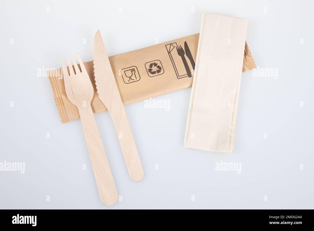 wooden fork knife and recycled napkin on recyclable packaging isolated