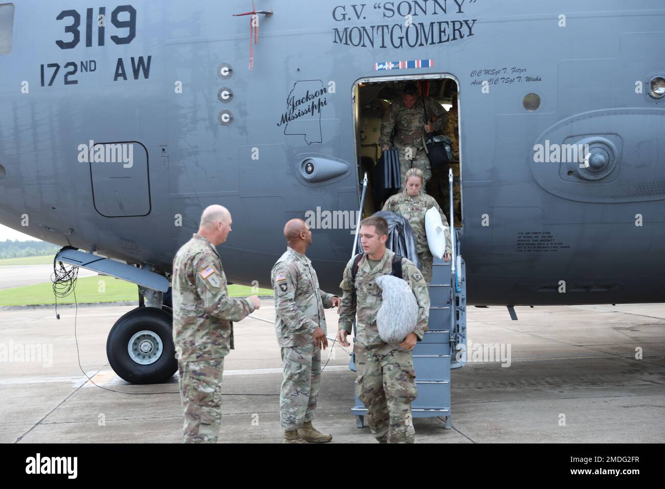 Soldiers with the 1st Battalion, 204th Air Defense Artillery Regiment are greeted by Sgt. Maj. Robbye McMillan and Maj. Curwin Burk as they deboard a C-17 Globemaster III at the Allen C. Thompson Field Air National Guard Base, in Flowood, Mississippi after completing their Rim of the Pacific rotation at Fort Shafter, Hawaii, July 23, 2022. During the exercise, they provided air defense for the Army’s first Multi-Domain Task Force. RIMPAC provides a unique training opportunity while fostering and sustaining cooperative relationships among participants, which are critical to ensuring the safety Stock Photo