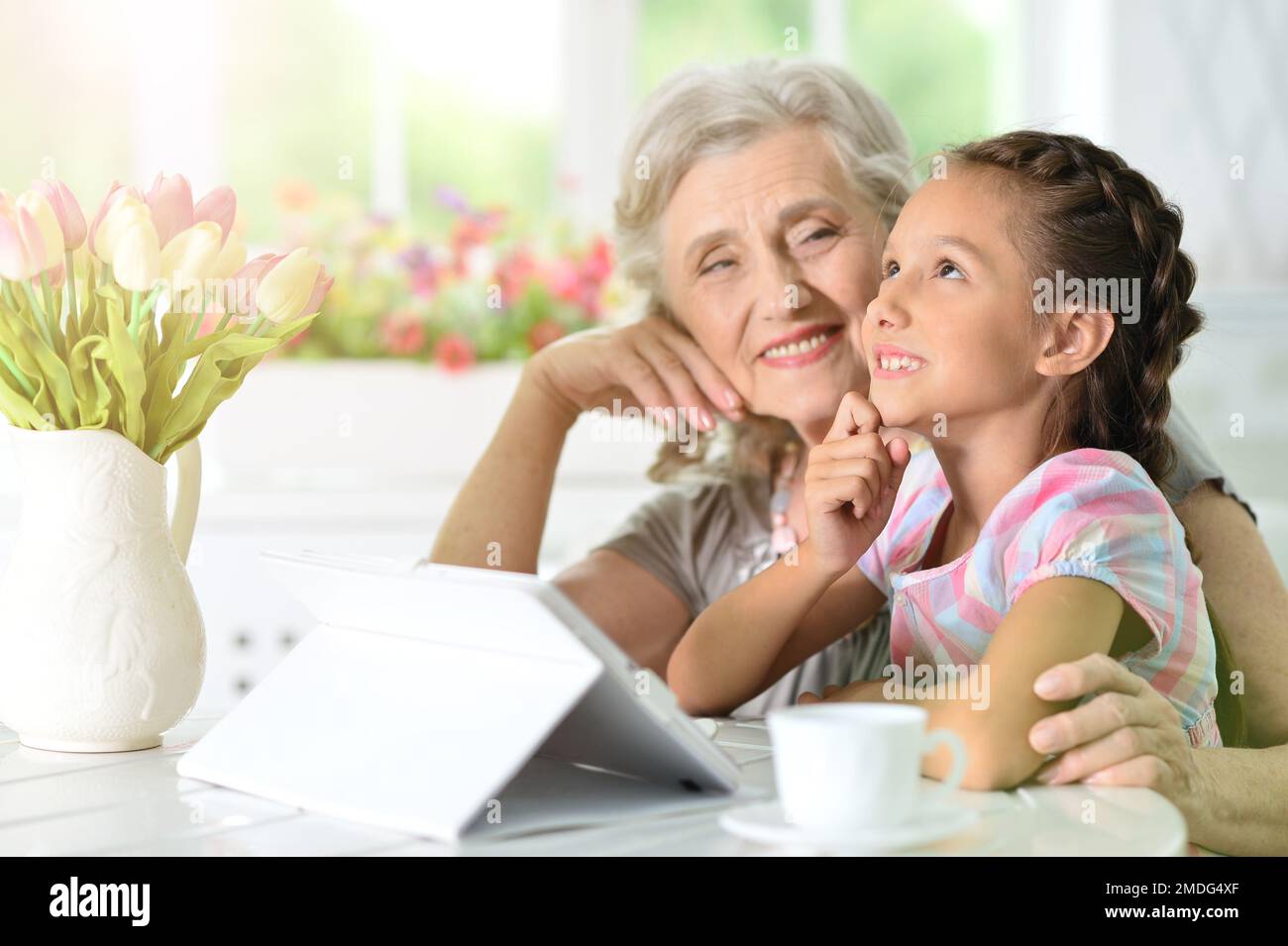 little girl with her grandmother looking at tablet Stock Photo - Alamy