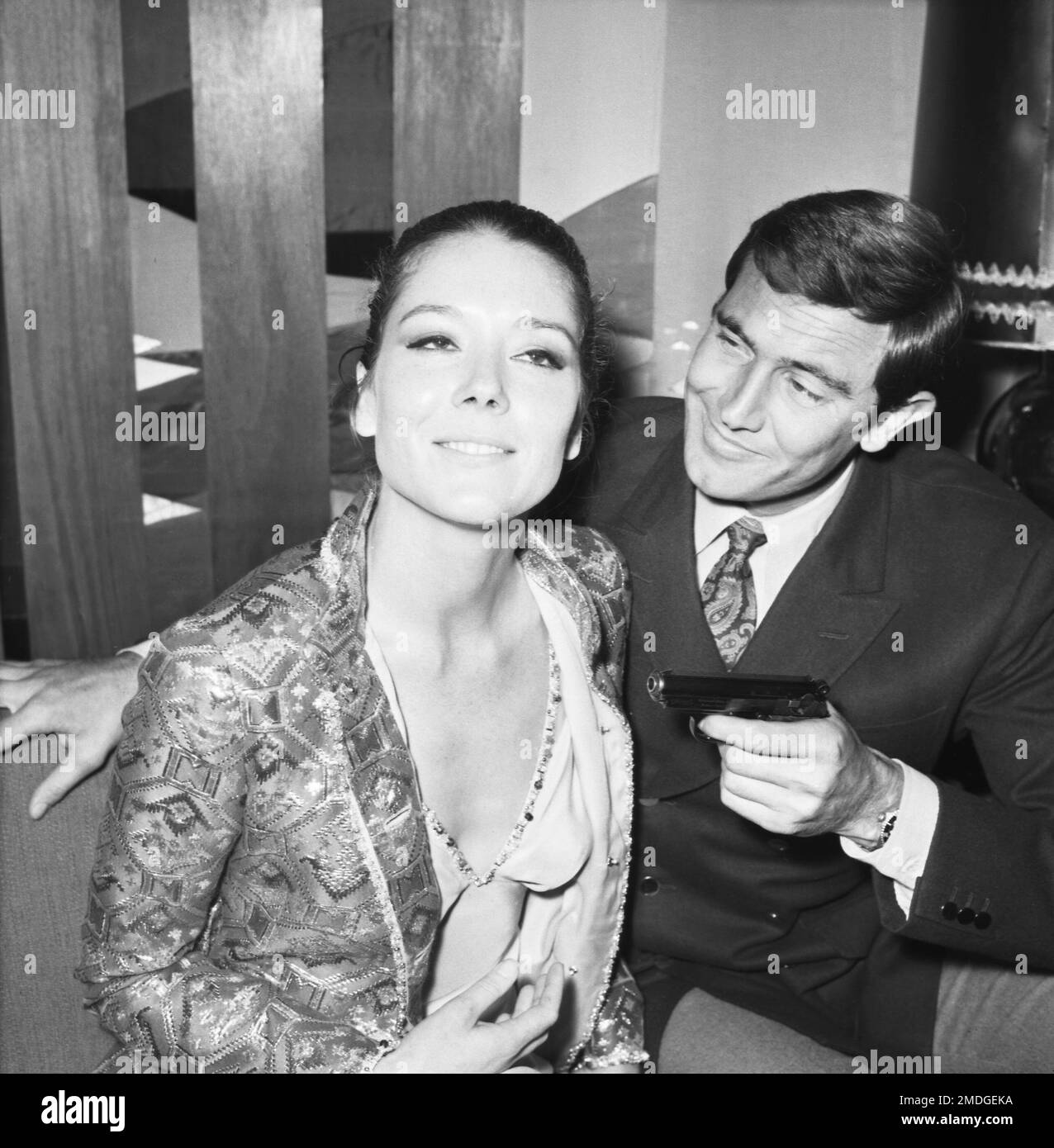 Australian George Lazenby, the new James Bond, playfully aims a pistol ...