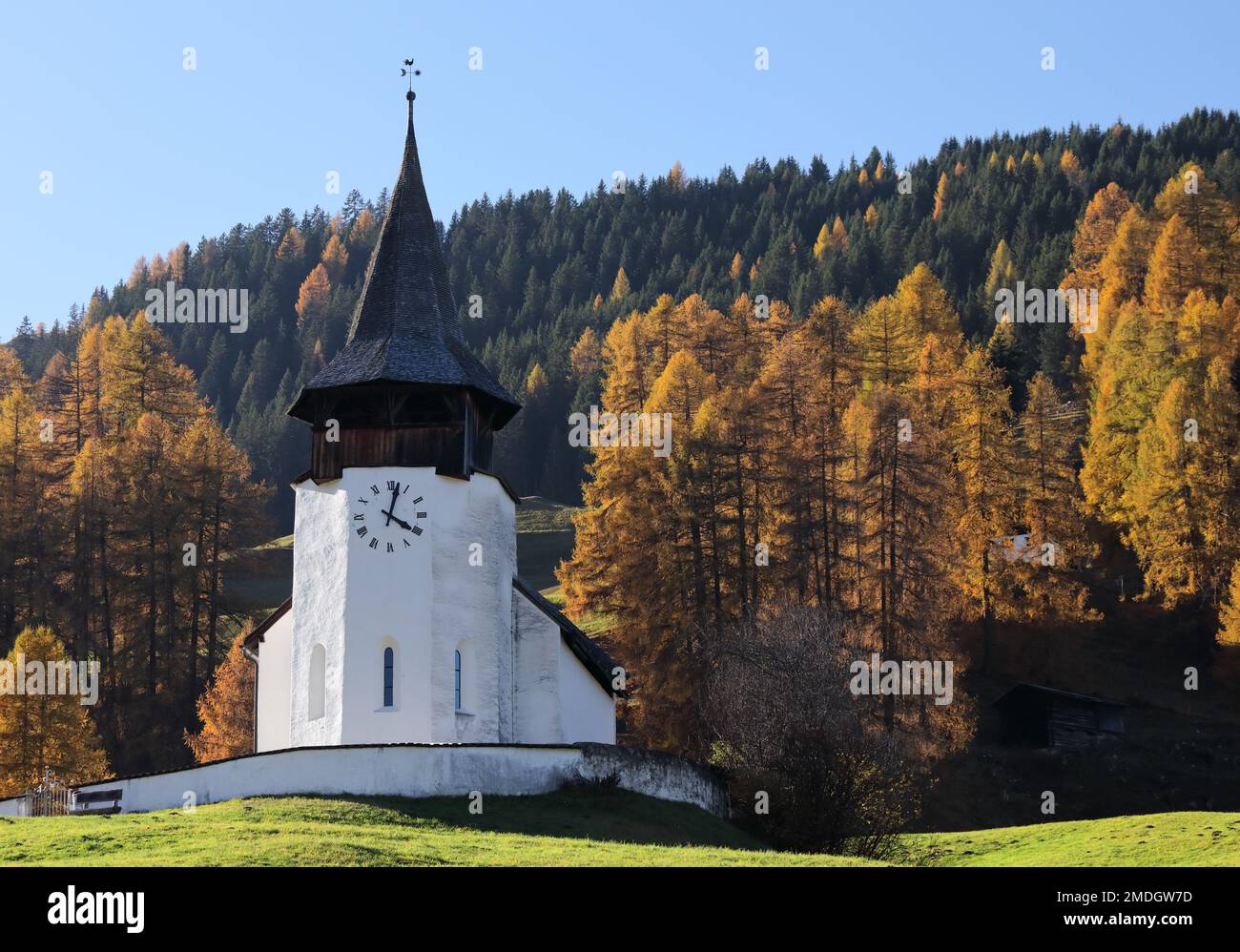 Reformierte Kirche church in the autumn Alps. Amazing landscape with small chapel on sunny meadow at Davos Frauenkirch, Davos, Switzerland Stock Photo