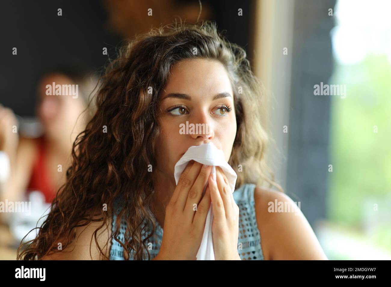 Woman cleaning mouth with a napkin in a restaurant Stock Photo
