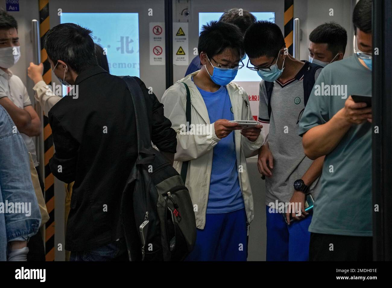 Students play online games inside a subway train in Beijing