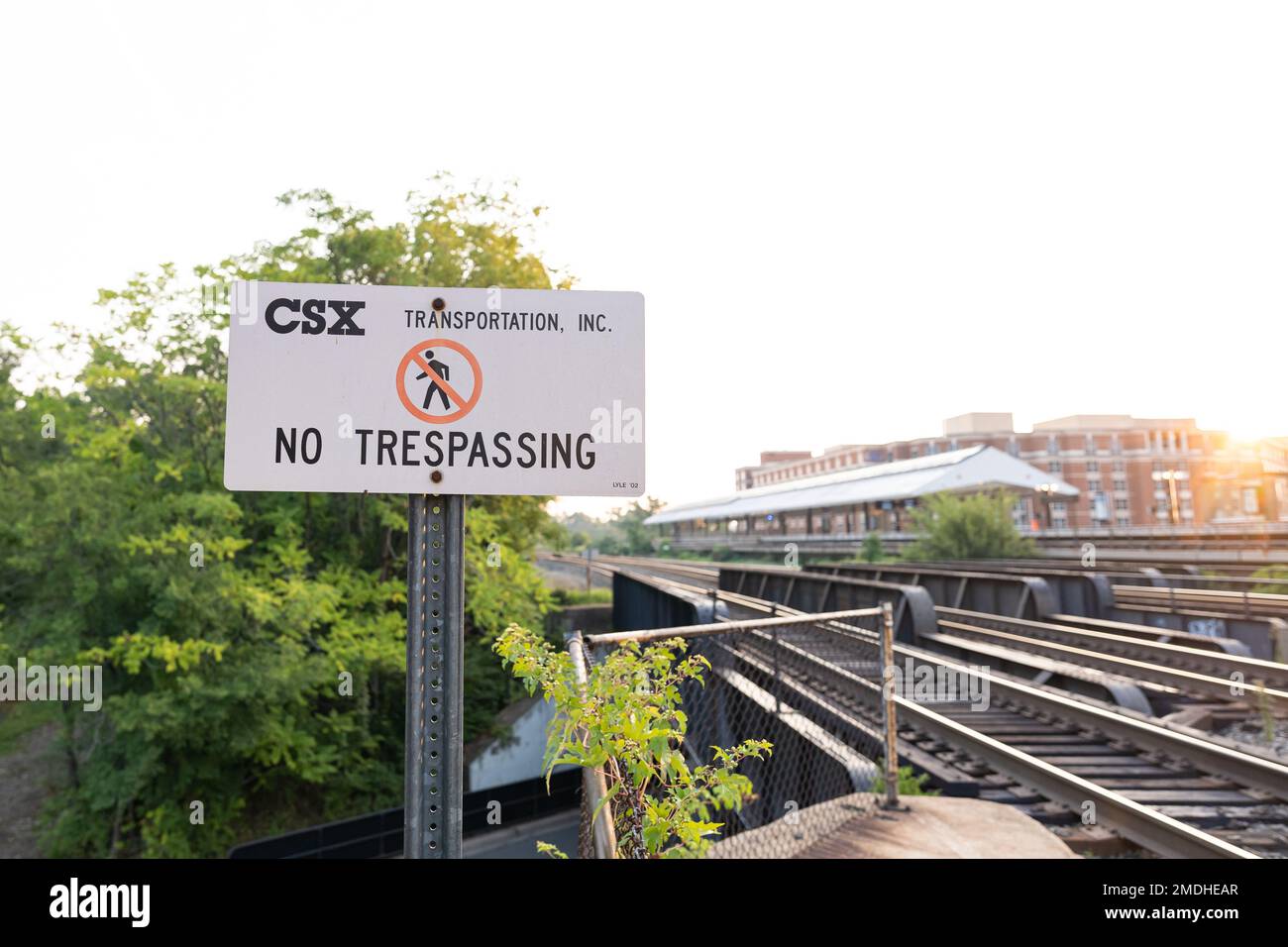 A no trespassing sign in front of train tracks owned by CSX. Stock Photo