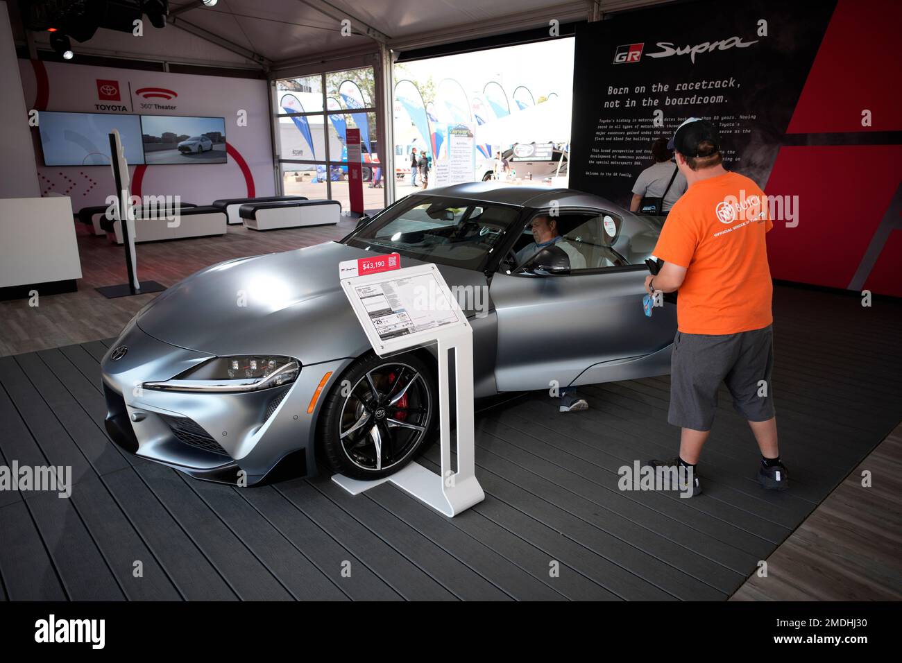 Prospective buyers examine a 2021 Supra on display in the Toyota display at the Denver auto show