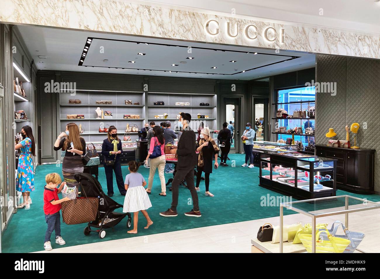 People shop in the Gucci department at a Saks Fifth Avenue store during
