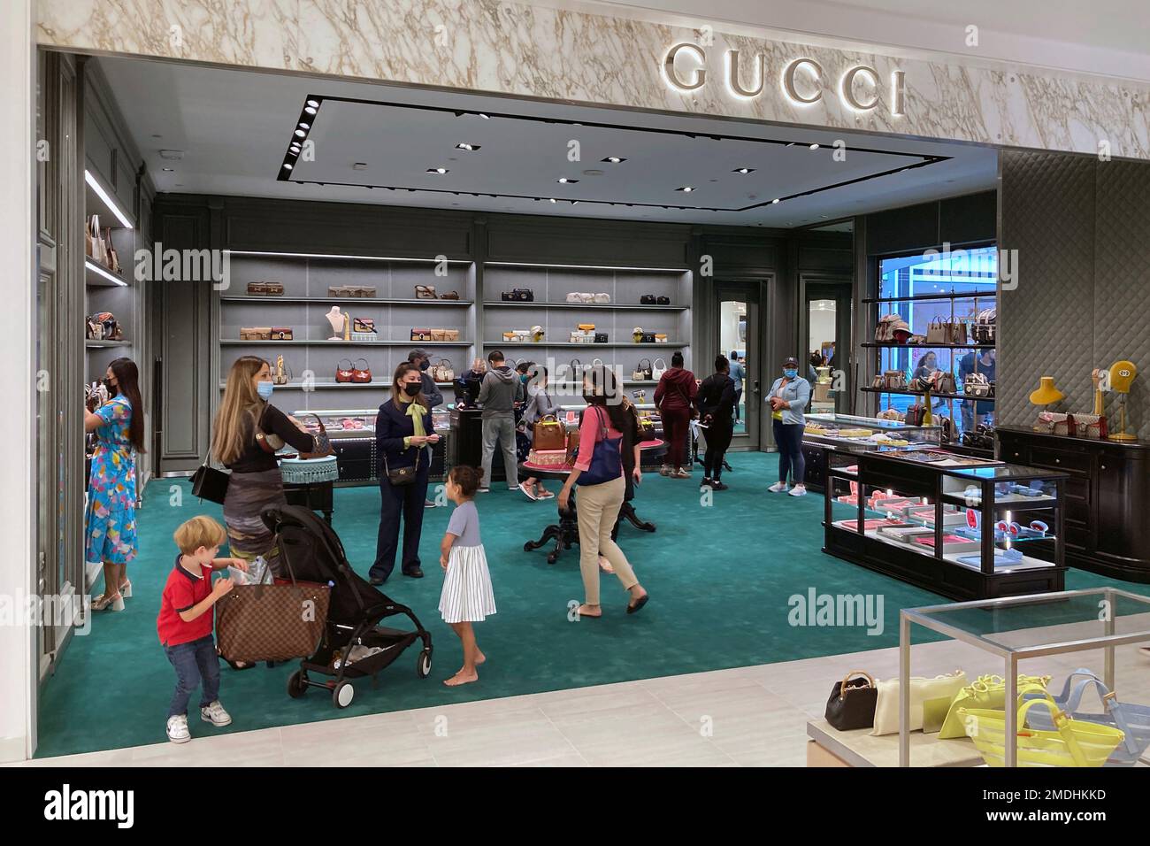 People shop in the Gucci department at a Saks Fifth Avenue store