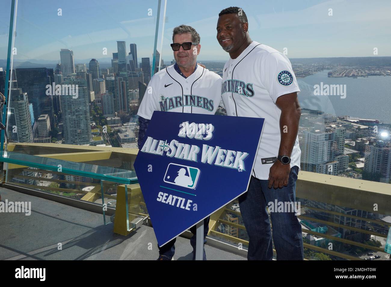 Seattle Mariners legends Edgar Martinez, left, and Ken Griffey Jr., right,  pose for a photo before raising a flag for the 2023 MLB All-Star Game on  the roof of the Space Needle