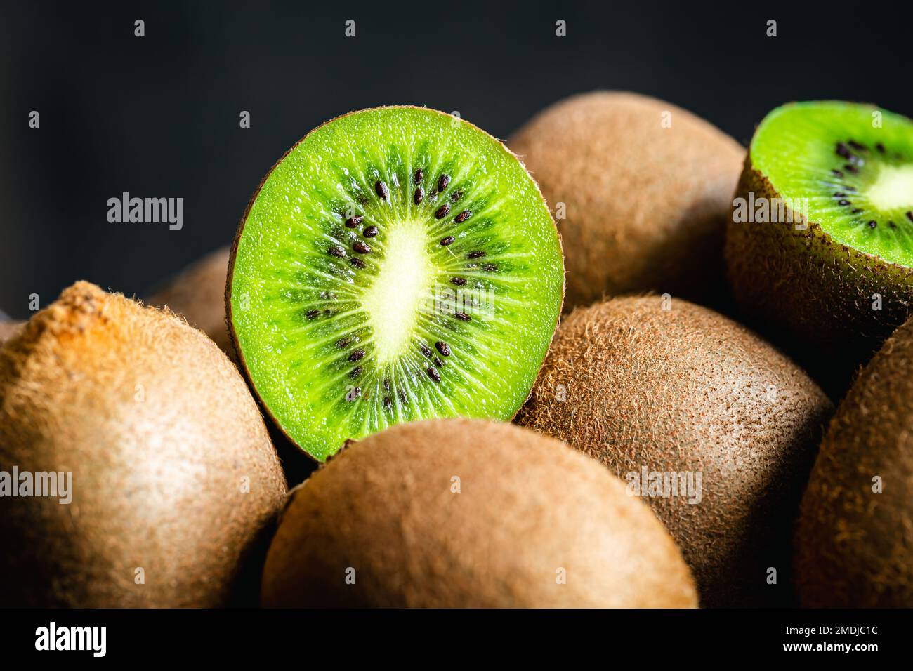 Ripe fruits of kiwi cut and whole, close -up Stock Photo - Alamy