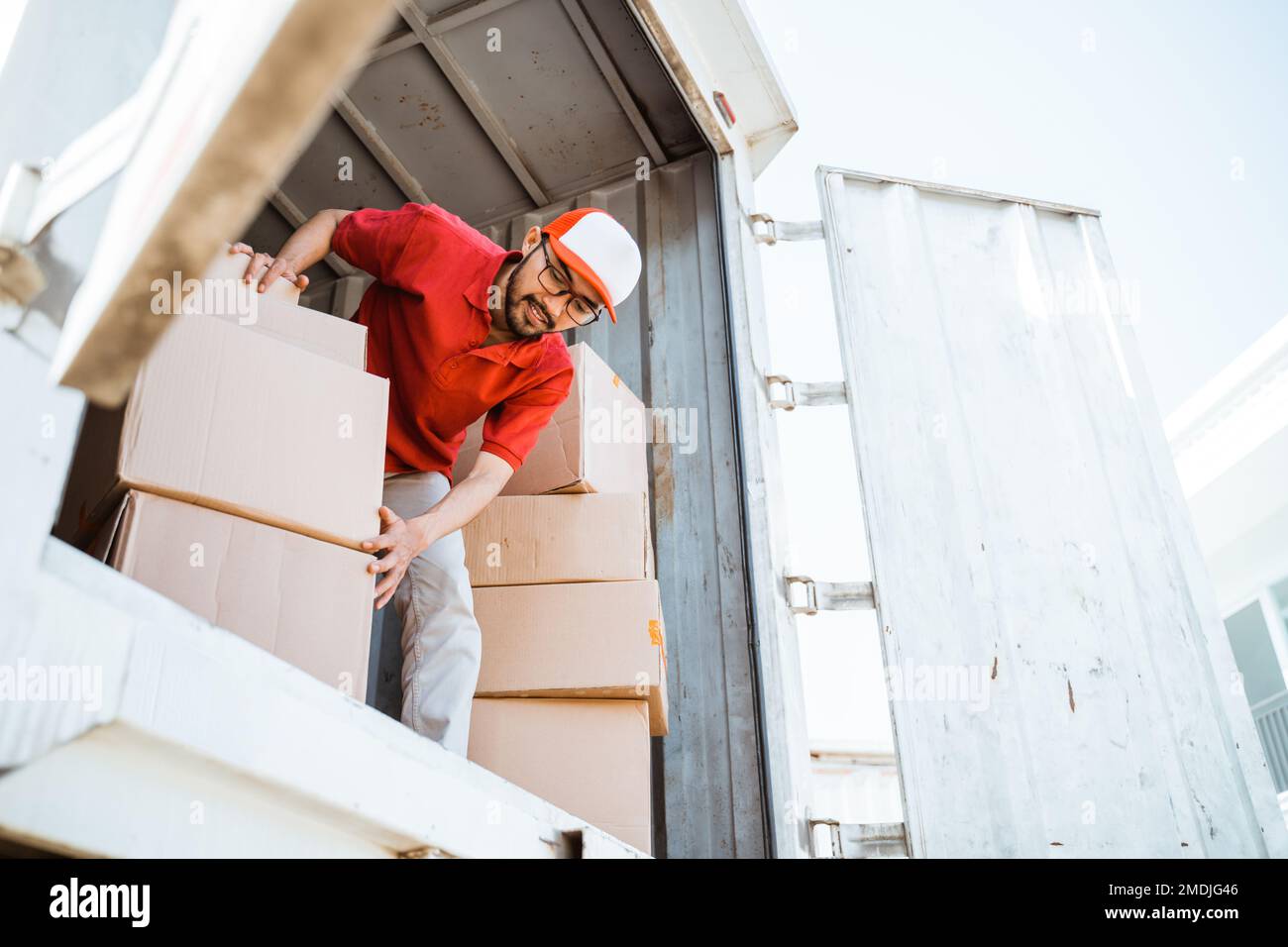 male employee working unloading boxes from containers Stock Photo