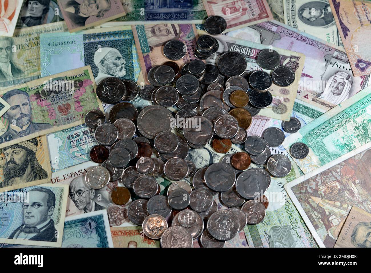 Old American coins of cents and dollars on various old cash money banknotes from different countries of the world, stack of multiple currencies, pile Stock Photo