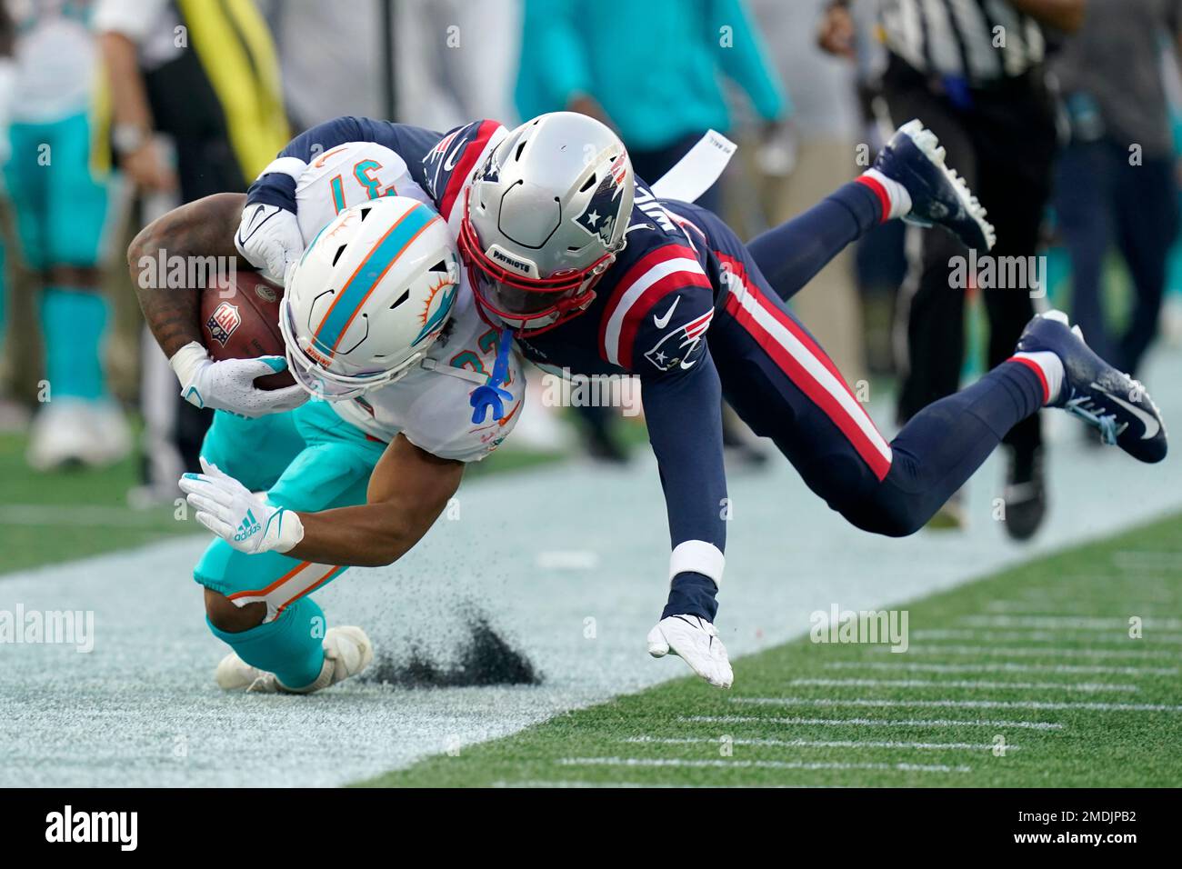 Miami Dolphins running back Myles Gaskin, left, is tackled by New England  Patriots cornerback Joejuan Williams, right, during the second half of an  NFL football game, Sunday, Sept. 12, 2021, in Foxborough,