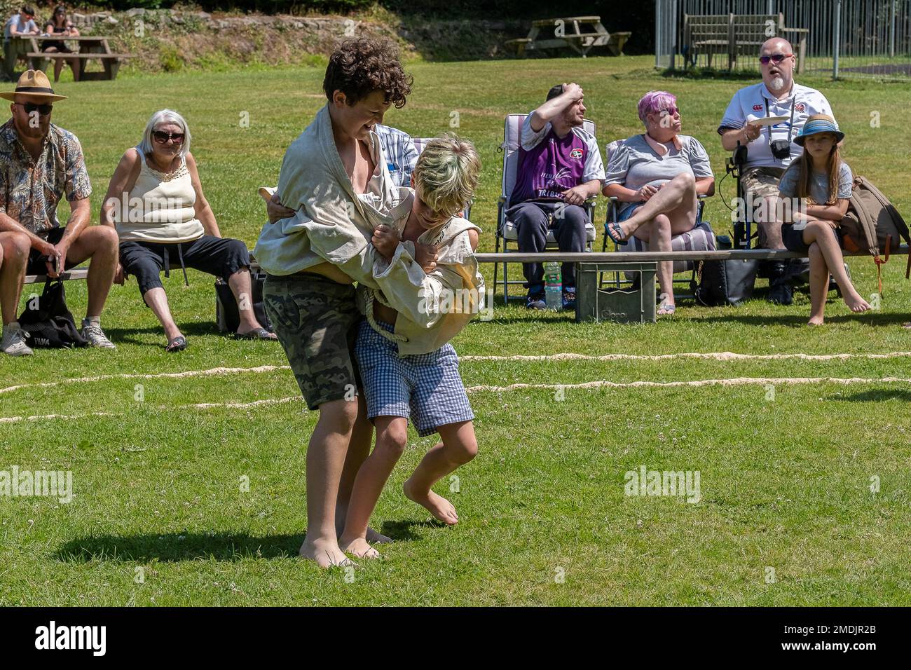 Two young boys competing in the Grand Cornish Wrestling Tournament on the picturesque village green of St Mawgan in Pydar in Cornwall in England in th Stock Photo