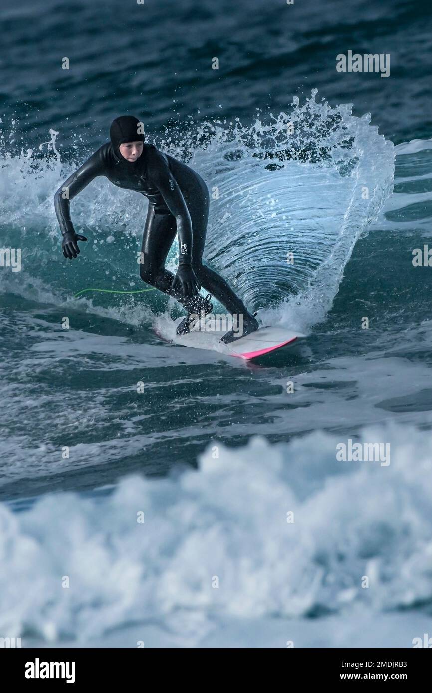 A surfer enjoying Winter surfing action at Fistral in Newquay in Cornwall in the UK. Stock Photo