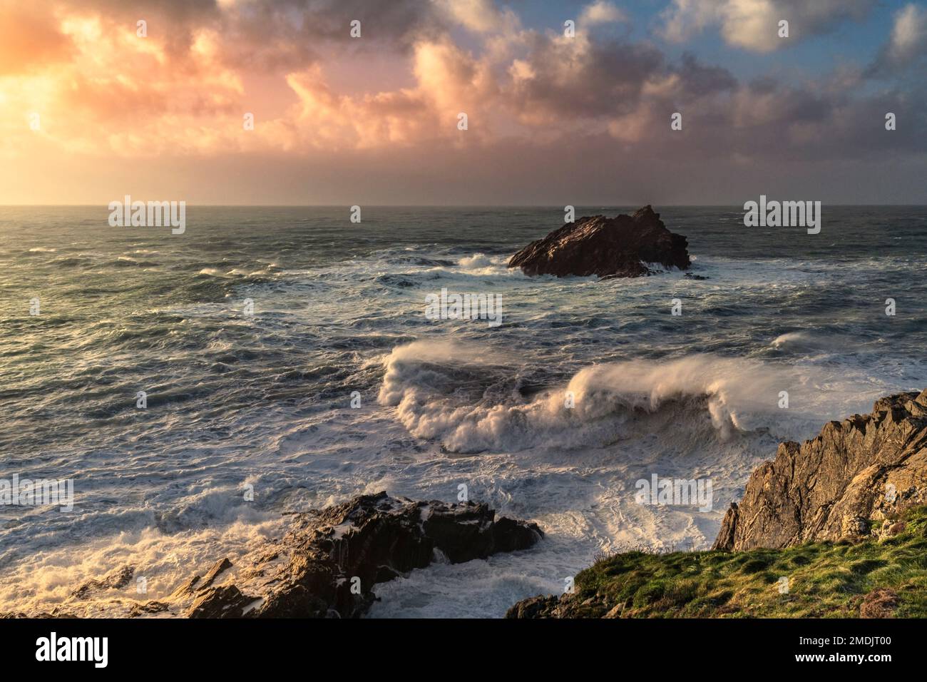 UK weather. Wild seas around the rocky island called The Goose Goose Rock on a stormy day over the wild rugged coast of Pentire Point East in Newquay Stock Photo