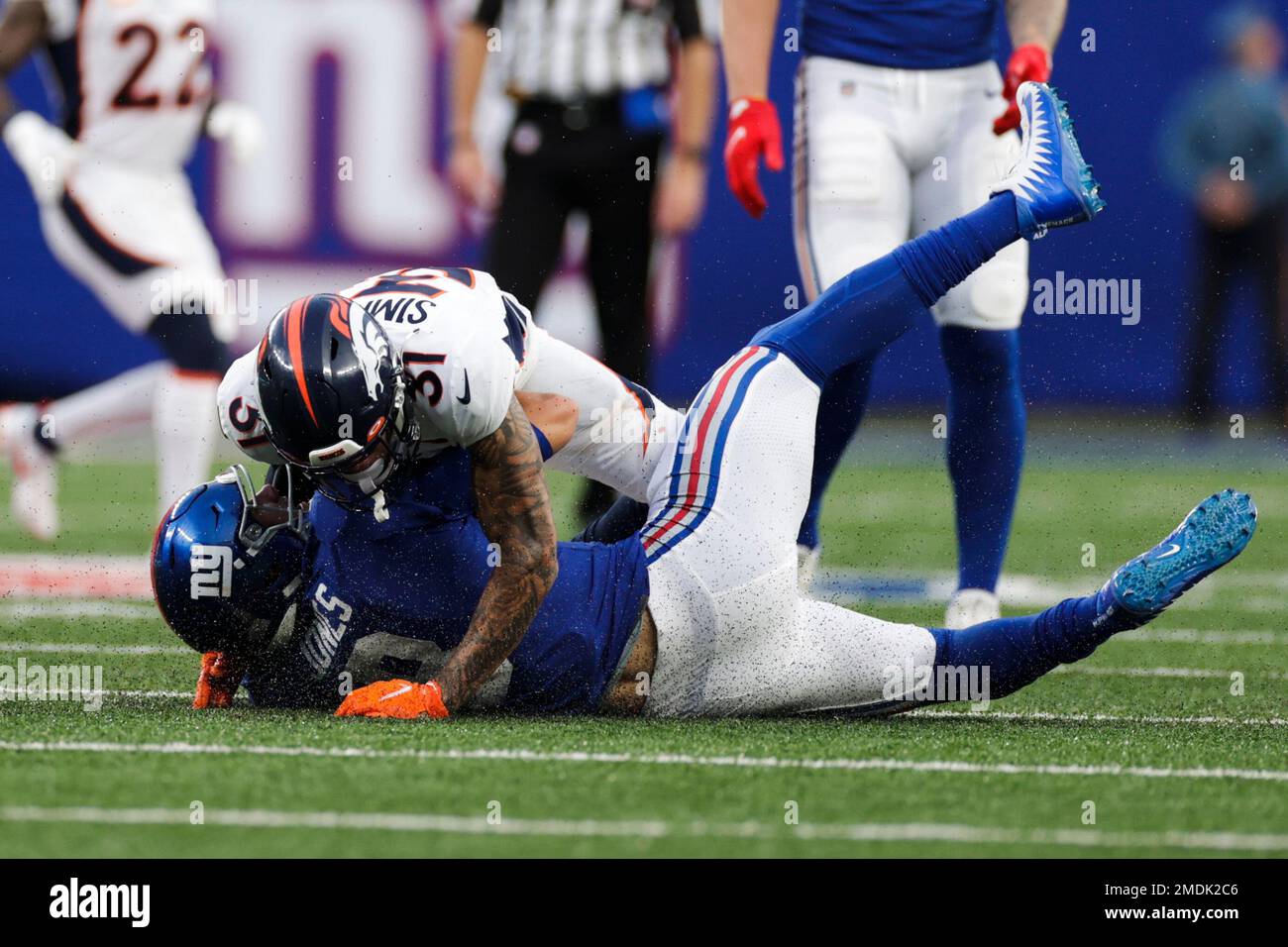 Denver Broncos' Justin Simmons (31) tackles New York Giants quarterback  Daniel Jones as Jones slides during the second half of an NFL football game  Sunday, Sept. 12, 2021, in East Rutherford, N.J.